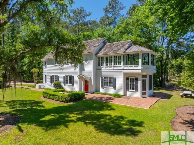 view of front of home with a front yard and a balcony