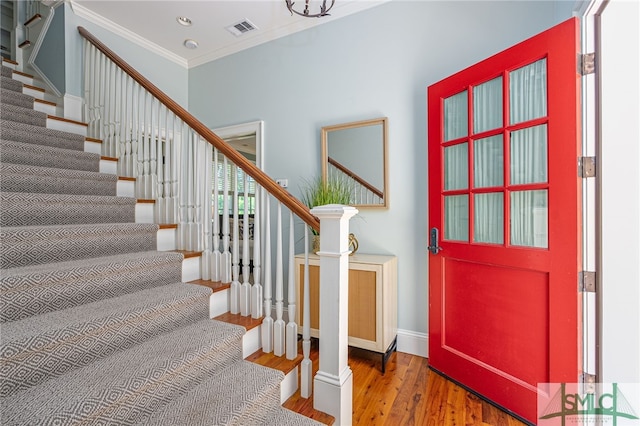 entrance foyer featuring ornamental molding and dark wood-type flooring