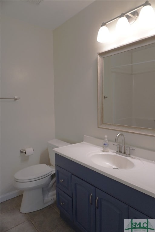 bathroom with toilet, tile flooring, and vanity