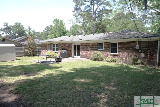 back of property with a yard and a patio