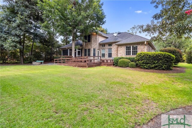 back of house featuring a deck and a yard