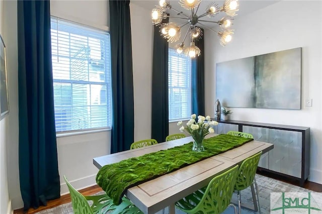 dining area featuring a wealth of natural light, dark wood-type flooring, and a notable chandelier