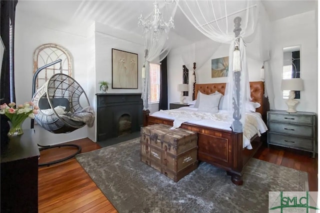 bedroom featuring a notable chandelier and dark wood-type flooring