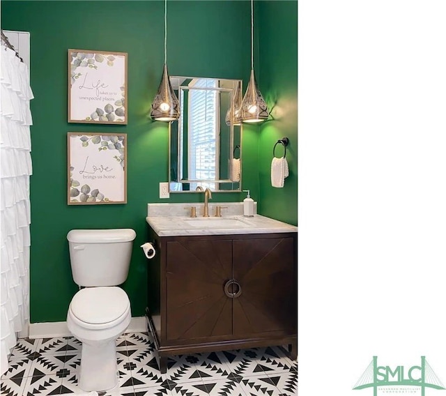 bathroom with vanity, toilet, and tile floors