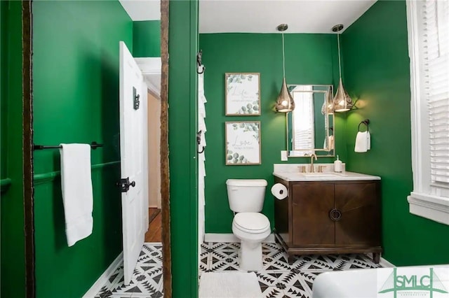 bathroom with tile flooring, toilet, and vanity