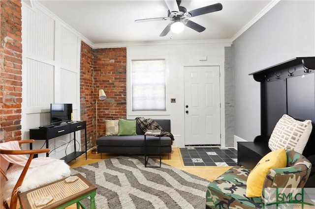 living room with brick wall, ornamental molding, and ceiling fan