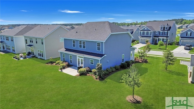 rear view of property featuring a garage and a yard