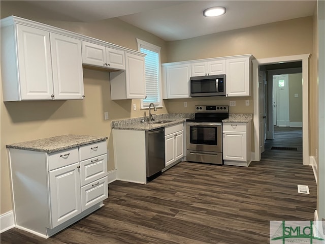 kitchen with dark hardwood / wood-style flooring, stainless steel appliances, white cabinetry, and sink