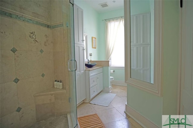 bathroom featuring walk in shower, vanity, toilet, and tile flooring