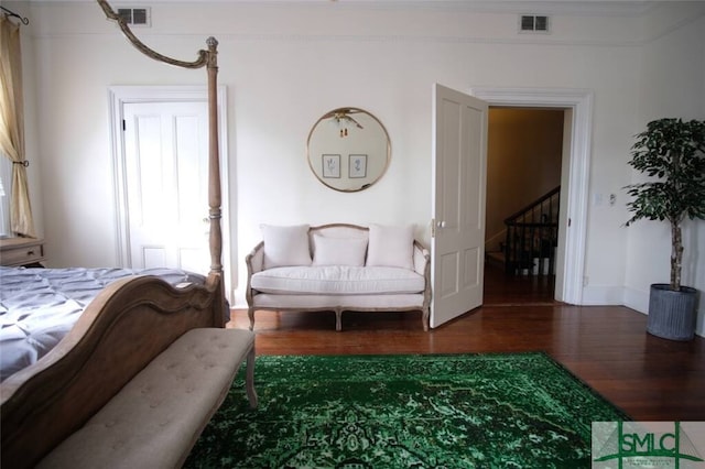 bedroom featuring dark wood-type flooring and crown molding