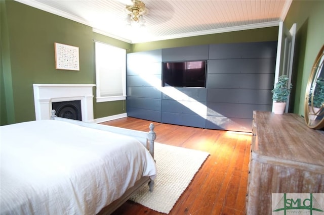 bedroom featuring ceiling fan, crown molding, and hardwood / wood-style flooring