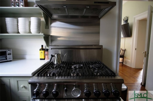 kitchen with hardwood / wood-style floors, wall chimney range hood, and range