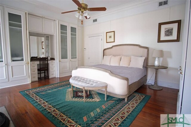 bedroom featuring ornamental molding, dark wood-type flooring, and ceiling fan