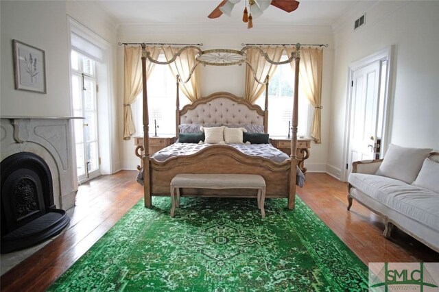 bedroom featuring ceiling fan, hardwood / wood-style floors, and multiple windows