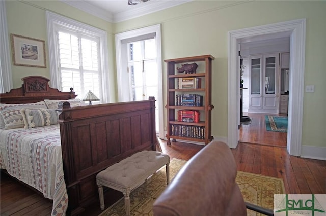 bedroom with dark hardwood / wood-style flooring and ornamental molding