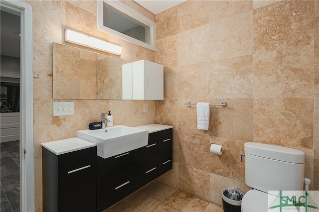 bathroom featuring vanity, toilet, tile floors, and tile walls