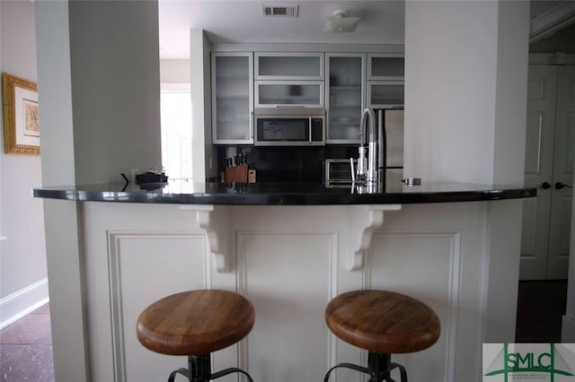 bar with appliances with stainless steel finishes, tile floors, and sink