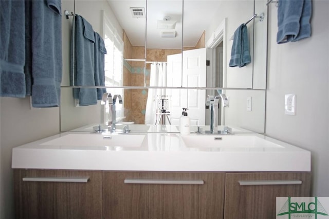 bathroom with vanity with extensive cabinet space and dual sinks