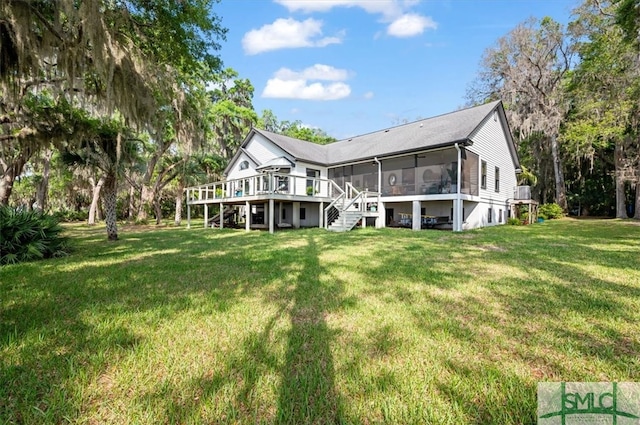 back of house with a deck, a sunroom, and a lawn