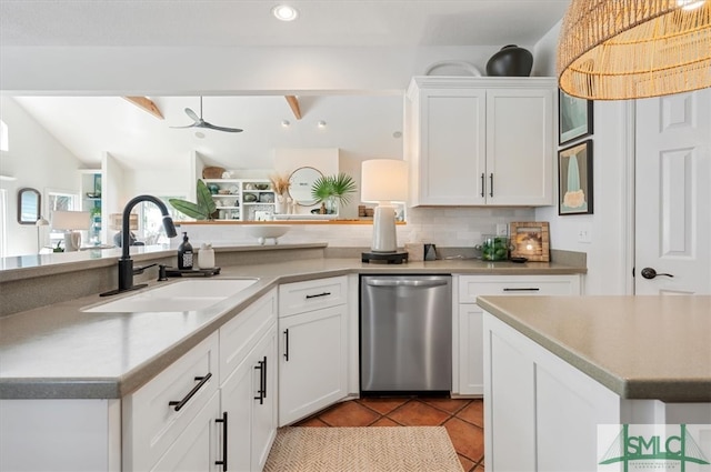 kitchen with white cabinets, sink, lofted ceiling with beams, light tile flooring, and stainless steel dishwasher