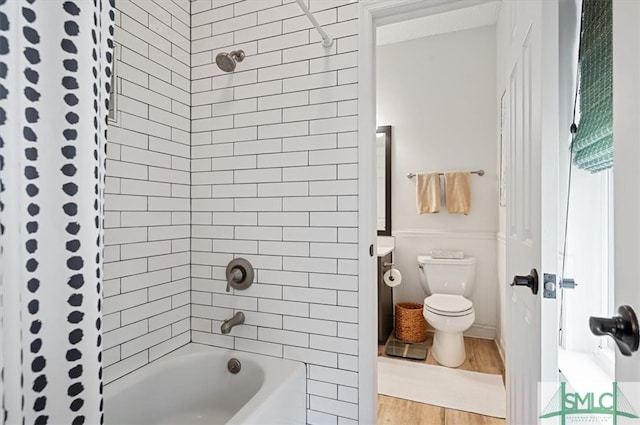 bathroom with shower / bath combination with curtain, hardwood / wood-style flooring, and toilet