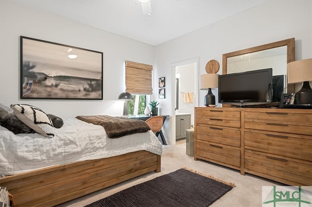 bedroom featuring light colored carpet, ceiling fan, and ensuite bathroom