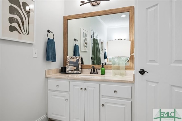 bathroom with crown molding and vanity