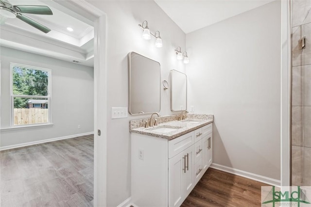 bathroom with vanity, hardwood / wood-style floors, a tray ceiling, and ceiling fan