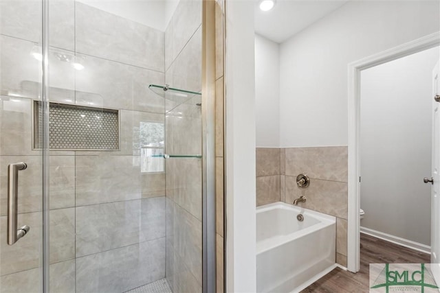 bathroom with independent shower and bath, wood-type flooring, and toilet