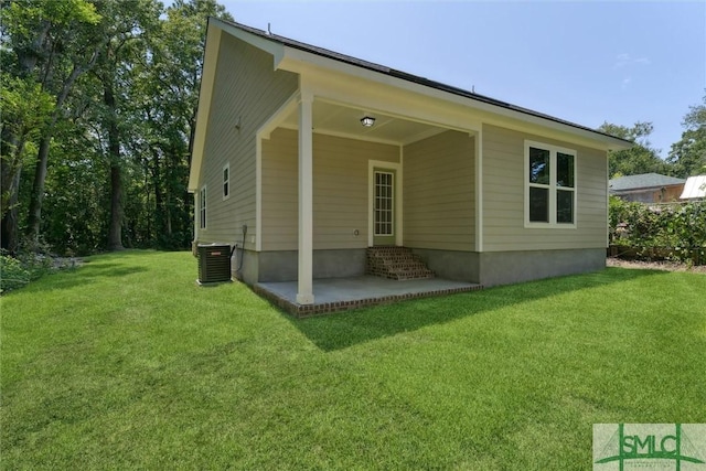 back of property with a patio area, central AC unit, and a lawn