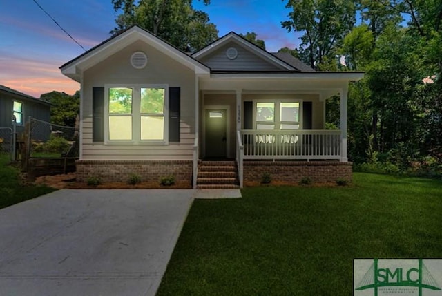 bungalow with a porch and a yard