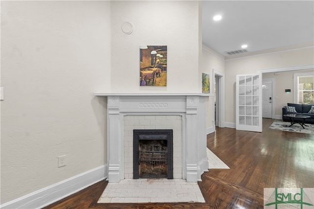 living room featuring ornamental molding, a brick fireplace, and dark hardwood / wood-style floors