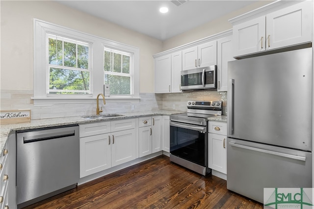 kitchen featuring white cabinets, dark wood-type flooring, appliances with stainless steel finishes, sink, and tasteful backsplash