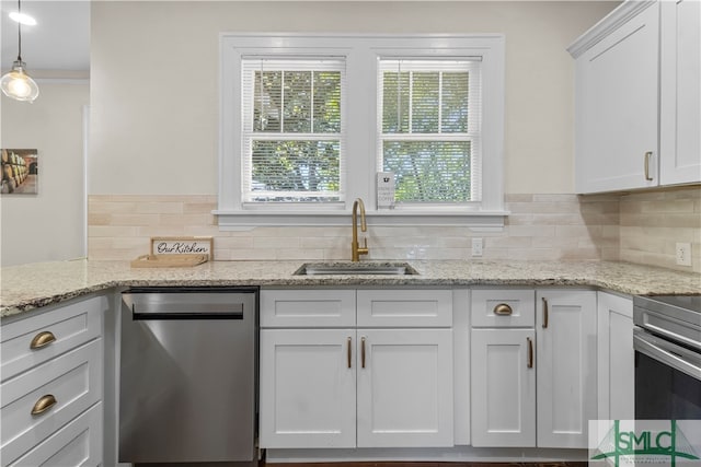 kitchen with a wealth of natural light, hanging light fixtures, sink, and stainless steel dishwasher