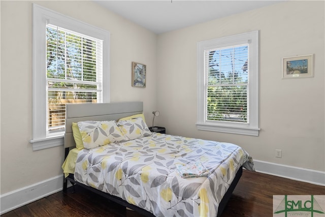 bedroom with multiple windows and hardwood / wood-style flooring