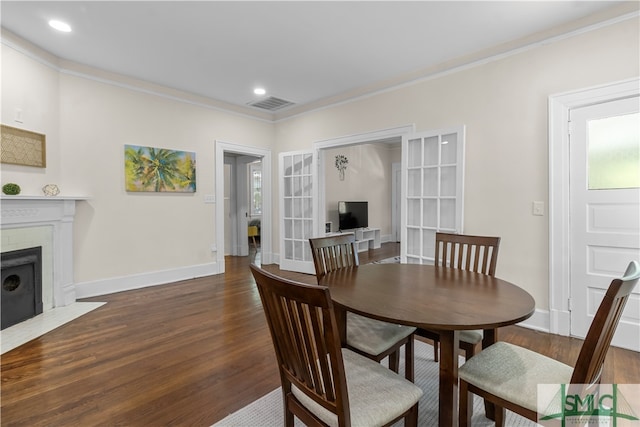 dining space with ornamental molding and dark hardwood / wood-style flooring