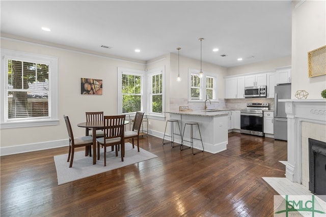 dining area with dark hardwood / wood-style floors, sink, and crown molding