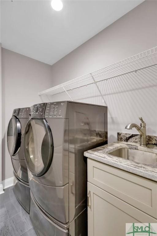 laundry room with cabinets, separate washer and dryer, and sink