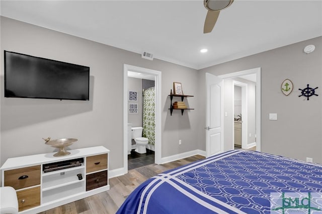 bedroom with ensuite bath, wood-type flooring, and ceiling fan