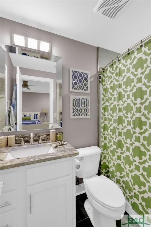 bathroom featuring tile patterned flooring, vanity, ceiling fan, and toilet