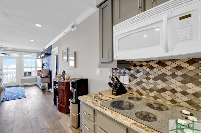 kitchen with gray cabinets, crown molding, white appliances, and decorative backsplash