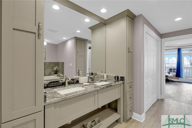 bathroom with vanity, hardwood / wood-style floors, and a washtub