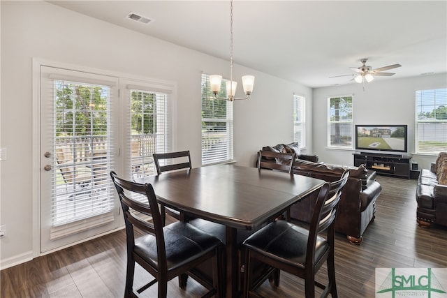 dining area with ceiling fan with notable chandelier, dark hardwood / wood-style floors, and plenty of natural light