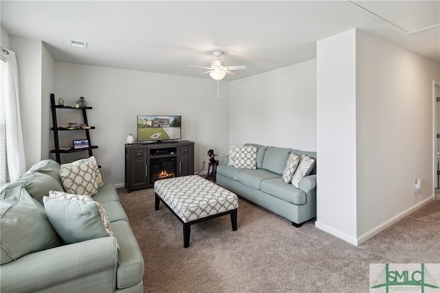 carpeted living room featuring ceiling fan and a fireplace