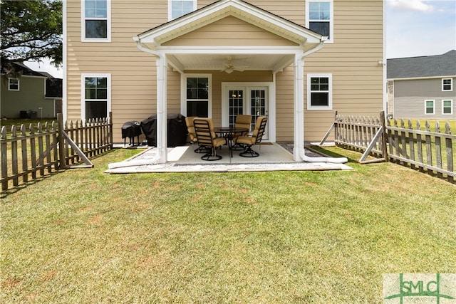 rear view of house featuring a lawn, ceiling fan, and a patio area