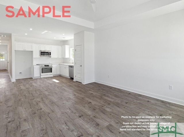 unfurnished living room with wood-type flooring and sink