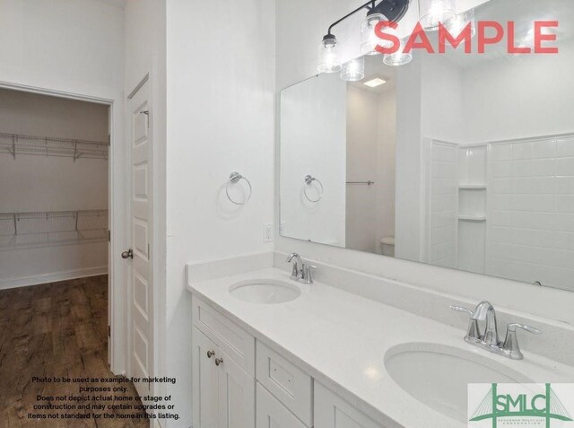 bathroom featuring double vanity, hardwood / wood-style flooring, and toilet