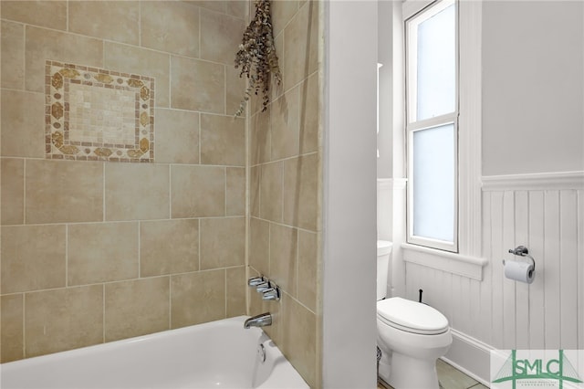 bathroom featuring tiled shower / bath combo and toilet