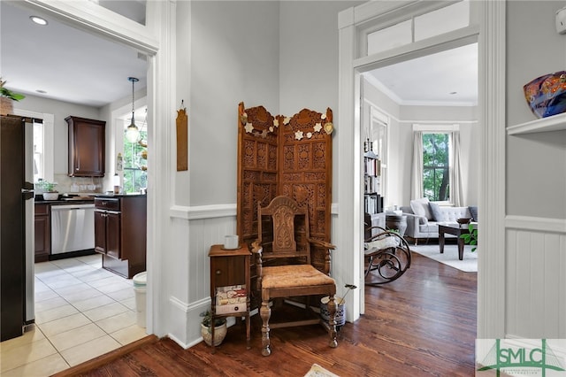 hallway featuring crown molding and light tile floors