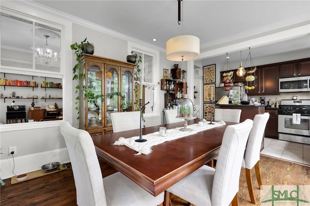 tiled dining space with a chandelier and crown molding